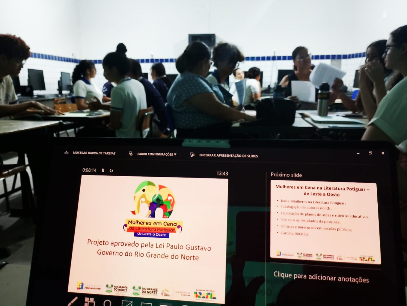 Professores sentado em sala de aula fazendo atividades